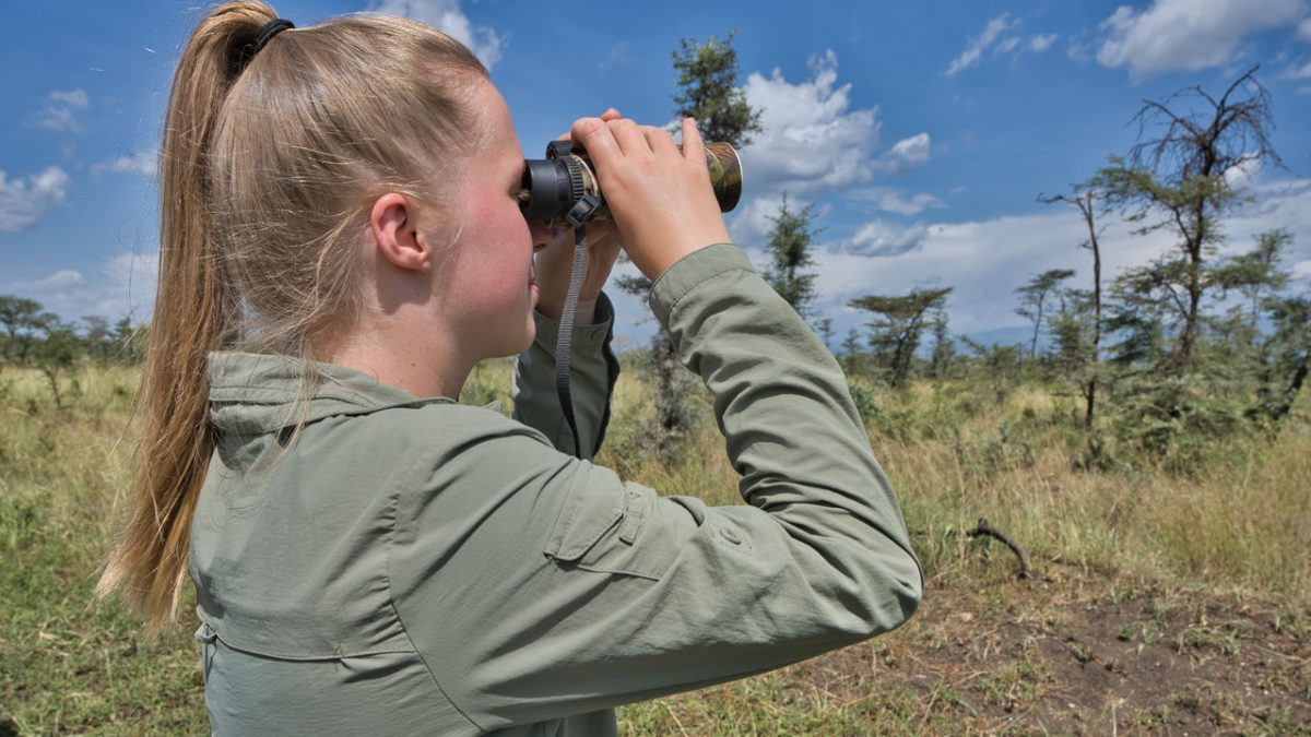 a tourist viewing wildlife, Rwanda safari packages